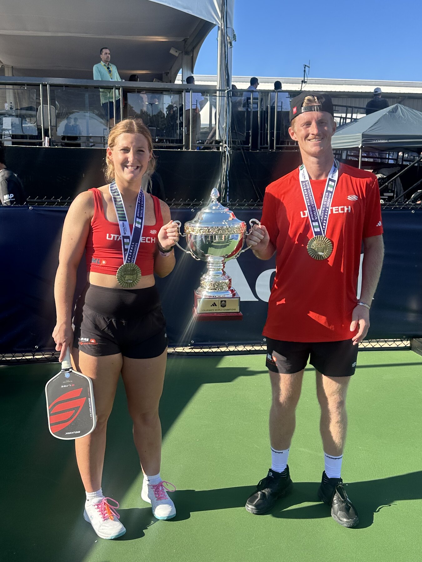 Clayton and Ella Boydston holding a pickleball championship trophy